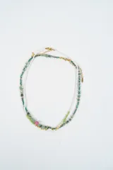 Set de dos collares de cuentas, uno compuesto por cuentas blancas y otro por una combinación de cuentas verdes, doradas y una cuenta central rosada.