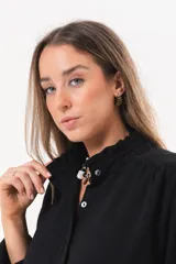 Camisa de manga larga color negro, de cuello redondo con frunces, abotonada en el frente y puños abiertos con tajo.