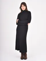 Vestido midi de punto color negro, con cuello alto y mangas largas, de corte ajustado en la parte superior y falda ligeramente acampanada.