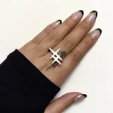 Anillo plateado con diseño geométrico abstracto.