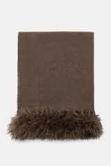 Pañuelo rectangular de color marrón, confeccionado en hilatura con lana, con detalle de aplicación de pelo sintético en los extremos.