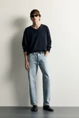 Jeans regular fit confeccionados en denim de algodón celeste con efecto lavado, de cinco bolsillos y cierre frontal con cremallera y botón.
