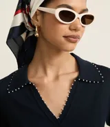 Blusa negra de punto con cuello polo, escote en V y mangas cortas. Detalle de mini perlas aplicadas en el cuello.