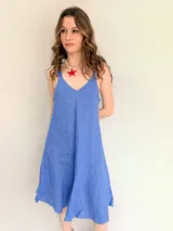 Vestido blanco de lino con breteles finos que se atan en los hombros.