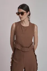 Conjunto de dos piezas color rojo, compuesto por un top sin mangas con detalle de volado fruncido en el bajo y un pantalón ancho de tiro alto con volados largos a lo largo de las costuras laterales exteriores.