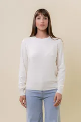 Buzo de punto color beige melange, de manga larga, cuello redondo y corte recto.