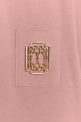 Camiseta de algodón con efecto lavado, cuello redondo y manga corta. Presenta un detalle de fornitura metálica aplicada en el pecho.