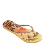 Sandalias tipo ojota Havaianas modelo Slim Tropical, con base amarilla estampada con motivos botánicos y tiras finas en color bronce metalizado.