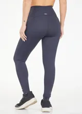 Calza deportiva de tiro alto y alta compresión, diseñada para moldear el cuerpo con un ajuste cómodo. Presenta un diseño liso y funcional, ideal para actividades físicas o uso diario.