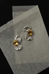 Aros caravanas de plata 950 con formas orgánicas y piedra citrino natural facetada en el centro. Cierre con perno y tope tipo mariposa.