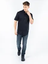 Camisa de manga corta azul marino, corte slim fit, con cuello clásico y cierre abotonado.