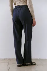 Pantalon de vestir azul marino, de corte recto y tiro alto, con cierre frontal y bolsillos laterales.