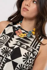 Vestido corto sin mangas con silueta acampanada y cuello cerrado, con estampado geométrico en blanco y negro.