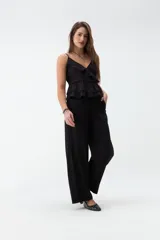 Pantalón de corte ancho y tiro medio, color verde militar, con cintura elástica ajustable mediante cordón y bolsillos laterales.