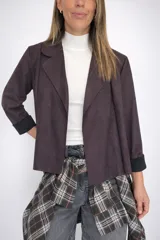 Chaqueta corta de diseño abierto con textura efecto ante, de corte recto y mangas largas con puños vueltos en contraste. Presenta solapas clásicas y una caída fluida, ideal para un estilo versátil y moderno.
