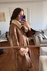 Tapado largo de cuero ovino color caramelo con cuello de piel sintética desmontable, detalles de pasamanería a tono en hombros y espalda y botones de guampa.