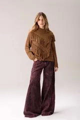 Sweater negro tejido de punto con cuello alto y silueta relajada, decorado con flecos marrones dispuestos en forma de V en la parte frontal.