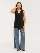 Pantalón de jean elastizado azul con terminación metalizada, corte wide leg, tiro medio, cierre delantero con botón, bolsillos laterales y traseros.