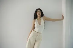 Bermuda de denim azul claro, de tiro medio y largo a la rodilla, con calce relajado y silueta amplia. Cuenta con bolsillos delanteros y traseros, y cierre frontal con botón y cremallera.