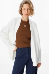 Saco abierto de punto color blanco, con diseño de textura cuadriculada en las mangas y corte holgado.