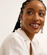 Caravanas maxi de metal con diseño de pez articulado y acabado martillado en color dorado.