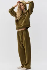 Buzo canguro color verde militar con capucha de doble capa, hombros caídos, bolsillo canguro y puños y bajo acanalados.