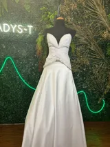 Vestido de fiesta blanco, con top irregular de tul plisado con aplique de galones plateados y falda de satén.