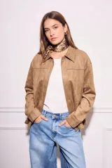 Sobrecamisa de gamuza sintética color camel, con corte oversize, cuello clásico con detalle de costura, cierre frontal con botones metálicos y mangas largas.