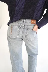 Jean de corte recto y tiro medio, color rosado con efecto acid wash y costuras diagonales en negro.