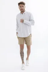 Camisa celeste a rayas verticales blancas, de manga larga y corte clásico.
