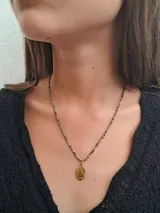 Collar corto de hematite facetado en tonos bronce y plata, con medalla dorada de la Virgen de la Rue du Bac (Medalla Milagrosa).