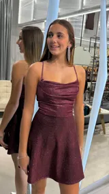 Vestido corto bordó con brillos, escote drapeado, tirantes finos y falda evasé.