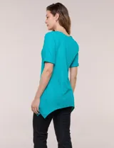 Blusa blanca de tejido de punto liviano con textura labrada en franjas verticales y caladas, de silueta evasé, con escote redondo, manga corta y ruedo asimétrico en picos.