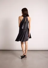 Vestido corto blanco con lunares negros, cuello halter y corte evasé.