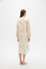 Vestido midi holgado de viscosa color beige, con mangas largas, cuello mao, cierre frontal con botones y detalle de bordado con lurex con diseño de hojas doradas.