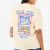 Camiseta de corte oversize color amarillo claro, con cuello redondo y mangas cortas con dobladillo. Presenta un estampado pequeño en el pecho con la frase 'The Authentic Market' y un gráfico de una rodaja de limón.