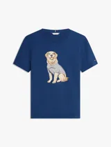 Remera de manga corta azul marino con cuello redondo, confeccionada en algodón. Presenta un diseño gráfico bordado en el pecho de un perro Golden Retriever vestido con una camiseta a rayas.