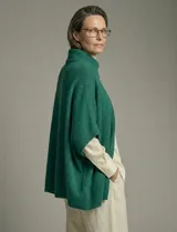 Capa tejida color fucsia, con cuello alto abotonado y mangas cortas estilo japonesa. Tejido de punto grueso.