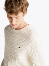 Sweater de punto trenzado color blanco con cuello redondo, mangas largas y detalles acanalados en puños y bajo, de la marca Tommy Hilfiger.