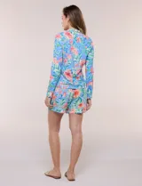 Campera liviana blanca de silueta entallada con protección solar UPF 50, cuello alto y cierre frontal completo. Cuenta con mangas largas y bolsillos laterales.