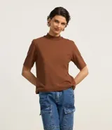 Remera negra de algodón, corte amplio, cuello alto en punto roma y mangas cortas.