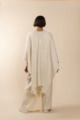 Ruana de lana fina color crudo con terminación envivada.