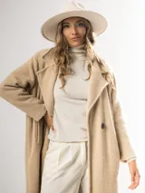 Tapado clásico color beige, con solapas de muesca, doble botonadura y bolsillos laterales.