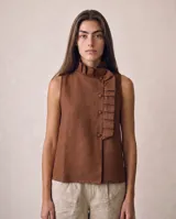 Blusa sin mangas de lino 100%, color marrón chocolate, con cuello alto plisado, cartera lateral asimétrica con pliegues y botones forrados al tono.