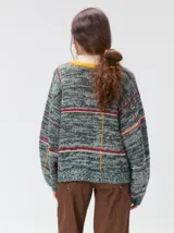 Sweater de punto con diseño geométrico y gráfico frontal en color rojo. Presenta cuello redondo, mangas largas holgadas y un ajuste suelto.