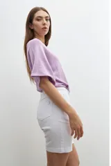 Bermuda de denim blanca, tiro medio, con cinco bolsillos y dobladillo en el borde de la pierna.