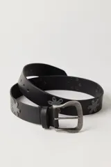 Cinturón de cuero negro con tachas metálicas en forma de flor a lo largo de la tira y hebilla de metal con acabado envejecido.