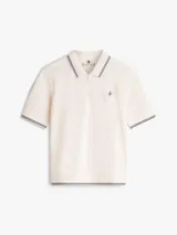 Chomba de piqué color blanco de Tommy Hilfiger, con mezcla de algodón elástico y lyocell. Presenta manga corta, cuello camisero con cierre frontal de cremallera y detalles de líneas oscuras en cuello, puños y dobladillo. Incluye logo bordado en el pecho.