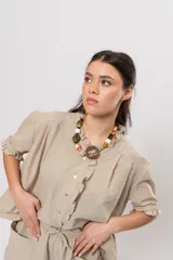 Camisa amplia de manga corta con estampa a cuadros en tonos verde y rosado, cuello con volados y cierre frontal con botones.