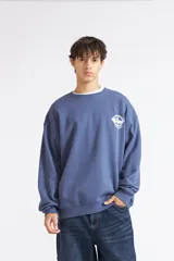 Buzo Quiksilver azul con cuello redondo, diseño oversize y pequeño estampado gráfico blanco en el pecho.